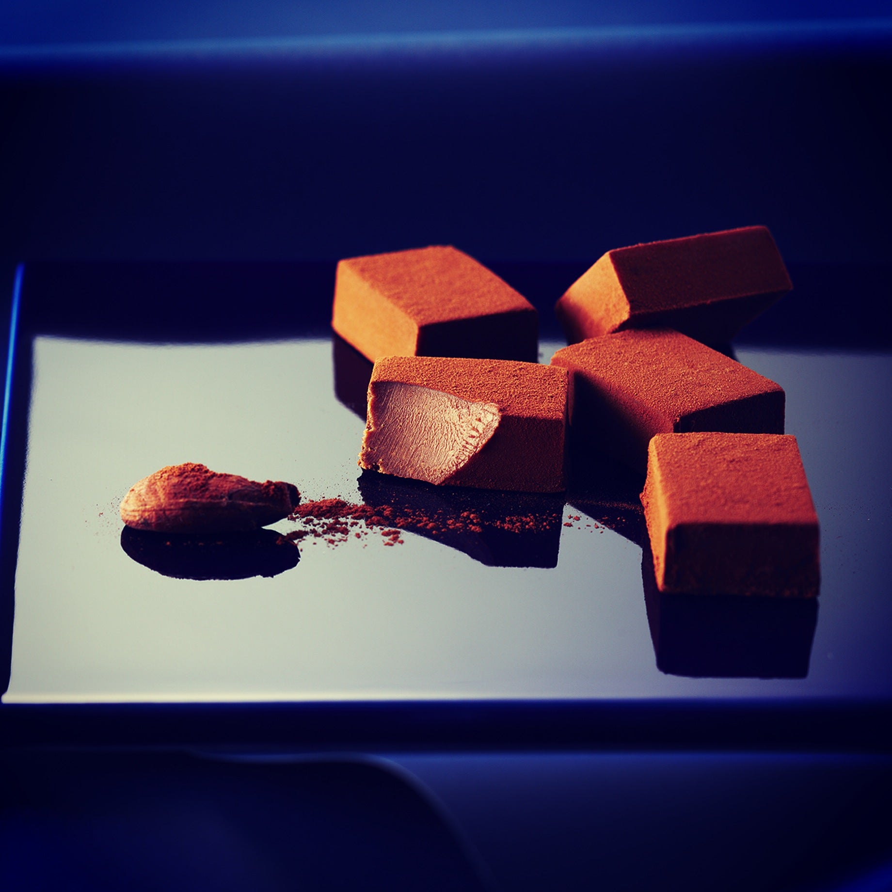 Image shows chocolates on a blue surface.