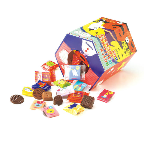 Image shows a hexagon-shaped printed box laying on a white surface in the colors of red, blue, green, yellow, orange, and white. Text on the box says ROYCE'. ROYCE' Halloween Wakuwaku Box. ROYCE'. White text on the side of the box says ROYCE'. Seen in the picture are illustrations of ghosts, pumpkins with facial expressions, bats, trees, towers, skulls, tombstones, and cats. Also seen are wrapped chocolates in red, blue, purple, blue, and orange as well as brown confections. Background is in white.